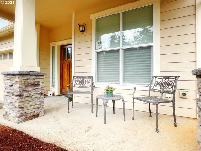 a view of two chairs and a table in the balcony