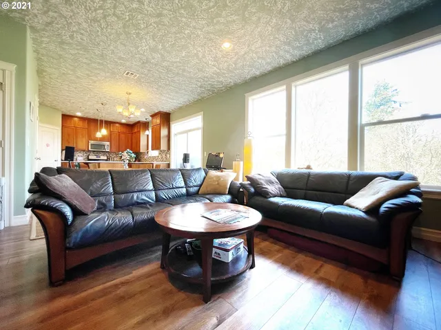 a living room with furniture a wooden floor and a large window