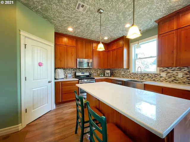 a kitchen with stainless steel appliances granite countertop a sink a stove and a refrigerator