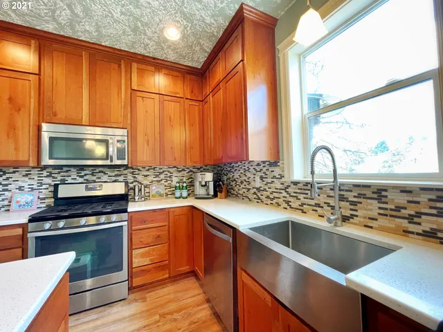 a kitchen with stainless steel appliances a stove sink and cabinets
