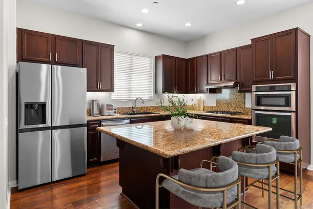 a kitchen with a refrigerator and a stove top oven
