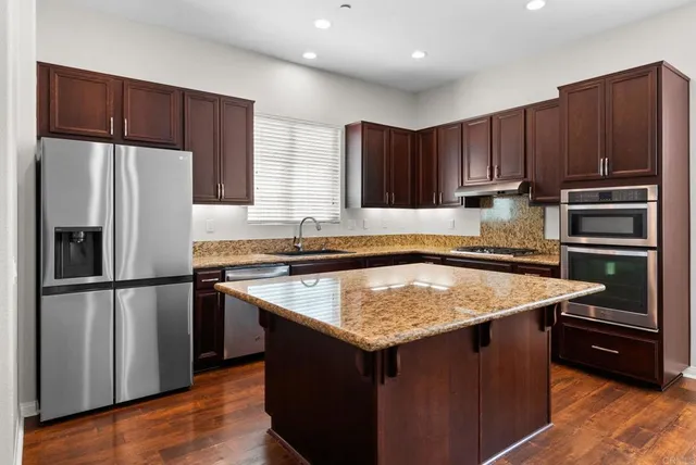 a kitchen with wooden cabinets a refrigerator and a sink