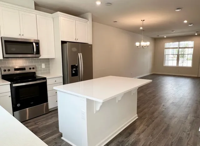 a kitchen with stainless steel appliances a refrigerator stove microwave and sink