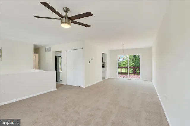 a view of a livingroom with a ceiling fan and window