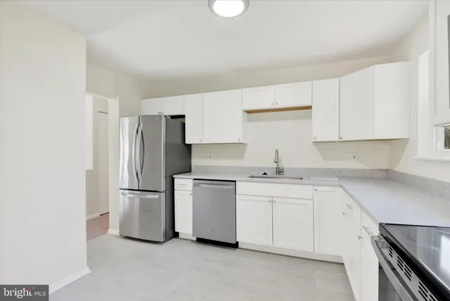 a kitchen with a sink a refrigerator and cabinets