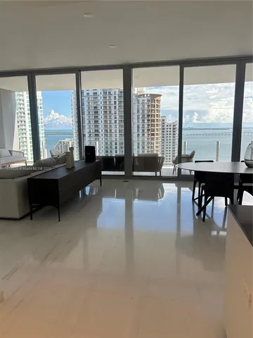 a living room with furniture and a large window with balcony view