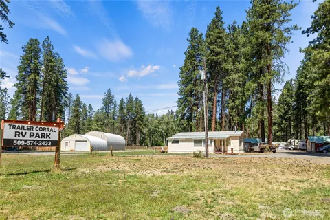 a view of a house with backyard and trees