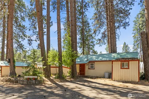 a view of a patio with table and chairs a fire pit and a large tree