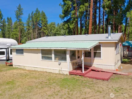 a view of a house with a backyard and a tree