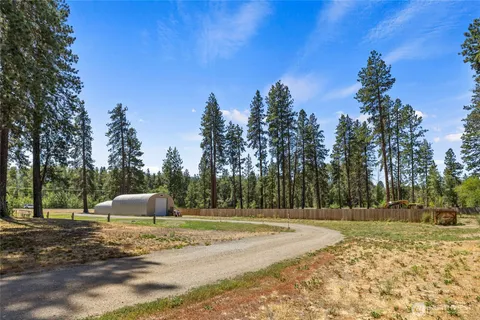 a view of a house with backyard and trees