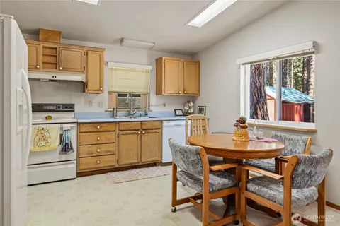 a kitchen with stainless steel appliances a dining table chairs and a refrigerator