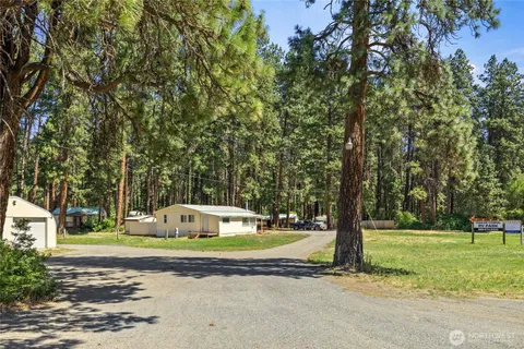 a front view of a house with a yard and trees