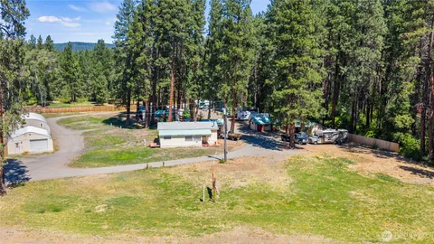 a view of a swimming pool with a bench and lawn chairs