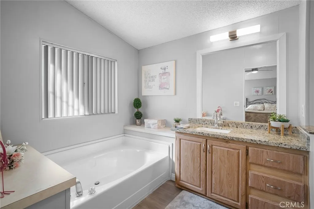 27701 Murrieta Road, Unit 37 Menifee, CA 92586 - Photo 13 of 24 a bathroom with a granite countertop sink and a bathtub