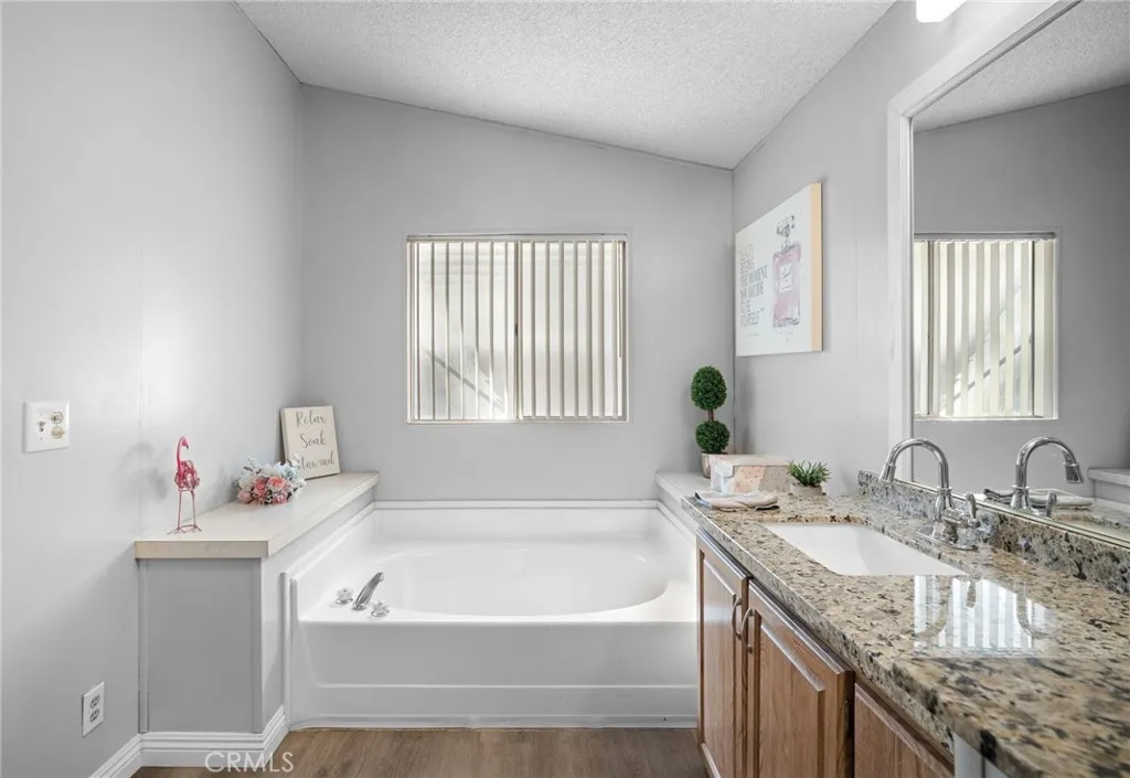 27701 Murrieta Road, Unit 37 Menifee, CA 92586 - Photo 14 of 24 a bathroom with a granite countertop tub sink and mirror