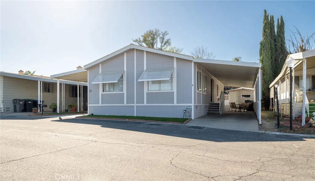 27701 Murrieta Road, Unit 37 Menifee, CA 92586 - Photo 23 of 24 a front view of a house with a yard and glass windows