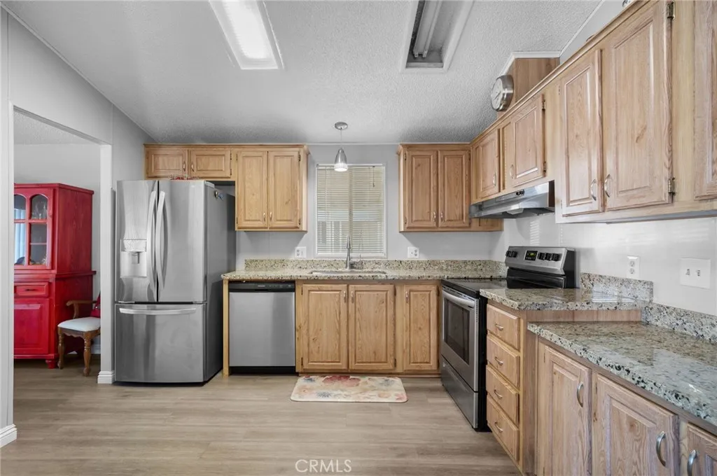 27701 Murrieta Road, Unit 37 Menifee, CA 92586 - Photo 9 of 24 a kitchen with stainless steel appliances granite countertop a refrigerator sink and cabinets