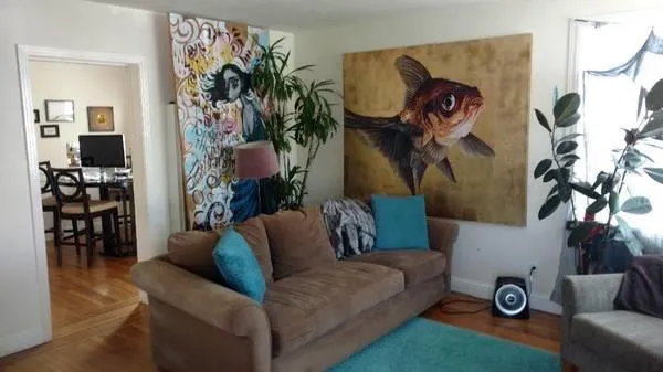 a living room with furniture and a wall painting