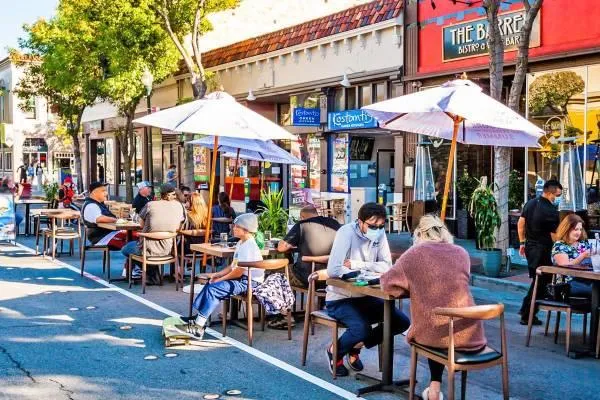 a group of people sitting outside of a restaurant
