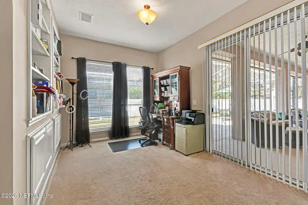 a view of a bedroom with furniture and floor to ceiling window