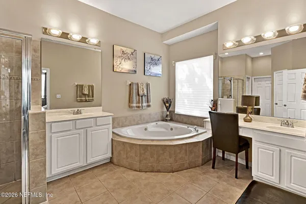 a large spacious bathroom with a sink a bathtub a mirror and a shower