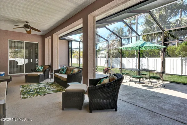 a living room with patio furniture and a potted plants