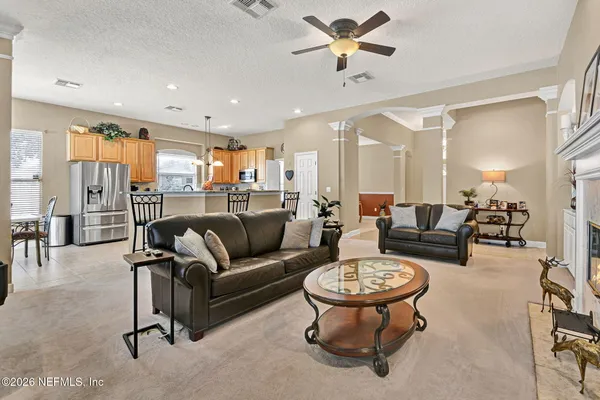a living room with furniture and a view of kitchen