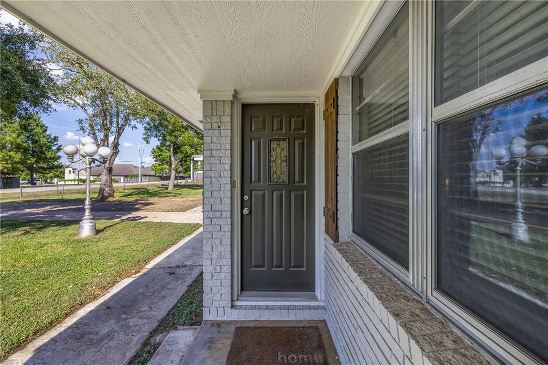 1906 Gun And Rod Road Brenham, TX 77833 - Photo 12 of 30 View of exterior entry with covered porch and a yard