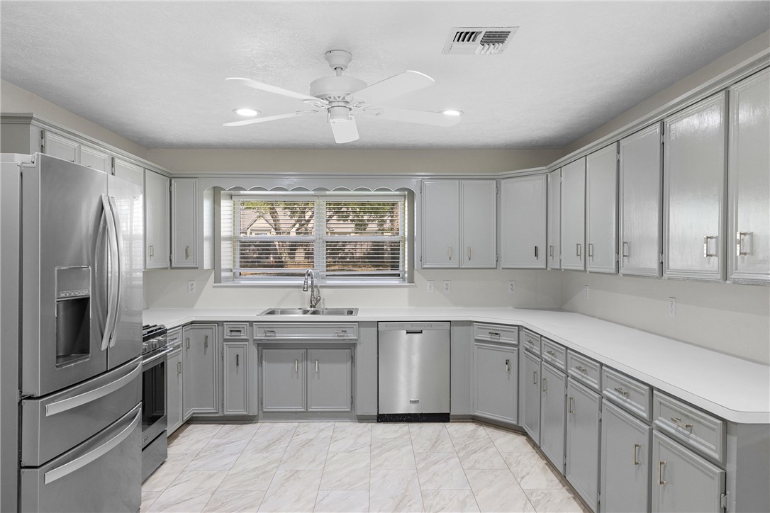 1906 Gun And Rod Road Brenham, TX 77833 - Photo 17 of 30 Kitchen with gray cabinetry, stainless steel appliances, light countertops, recessed lighting, and a ceiling fan