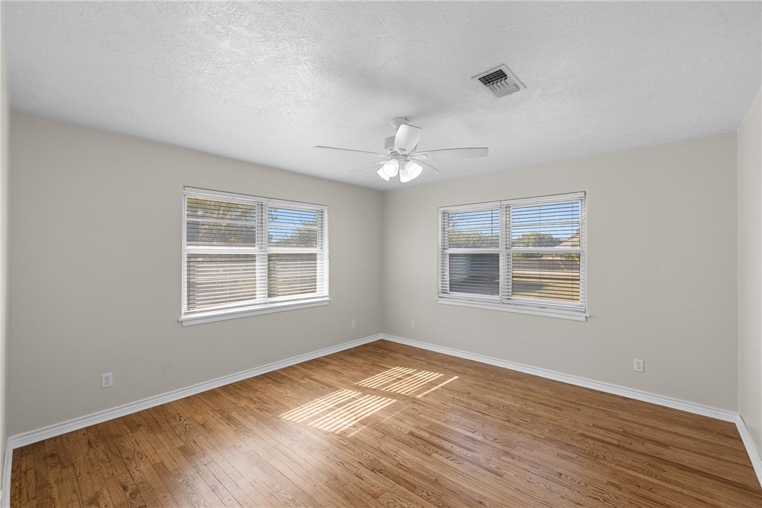 1906 Gun And Rod Road Brenham, TX 77833 - Photo 23 of 30 Spare room featuring light wood finished floors, a textured ceiling, and ceiling fan