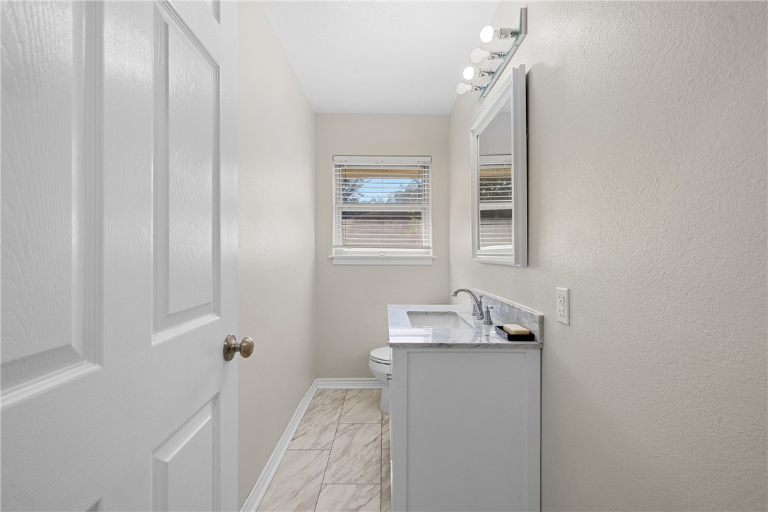 1906 Gun And Rod Road Brenham, TX 77833 - Photo 24 of 30 Bathroom featuring vanity and light marble finish flooring
