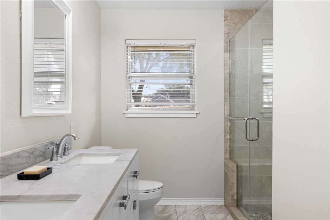 1906 Gun And Rod Road Brenham, TX 77833 - Photo 26 of 30 Bathroom featuring double vanity and a shower stall