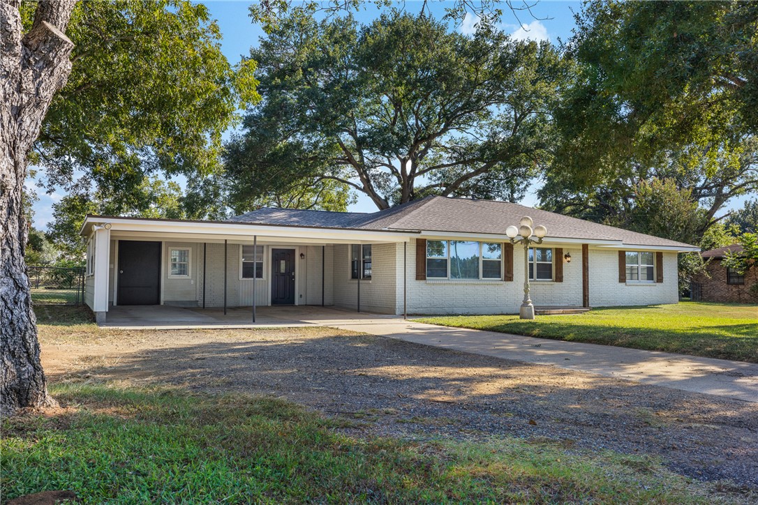 1906 Gun And Rod Road Brenham, TX 77833 - Photo 5 of 30 Single story home featuring driveway, an attached carport, a front lawn, and brick siding