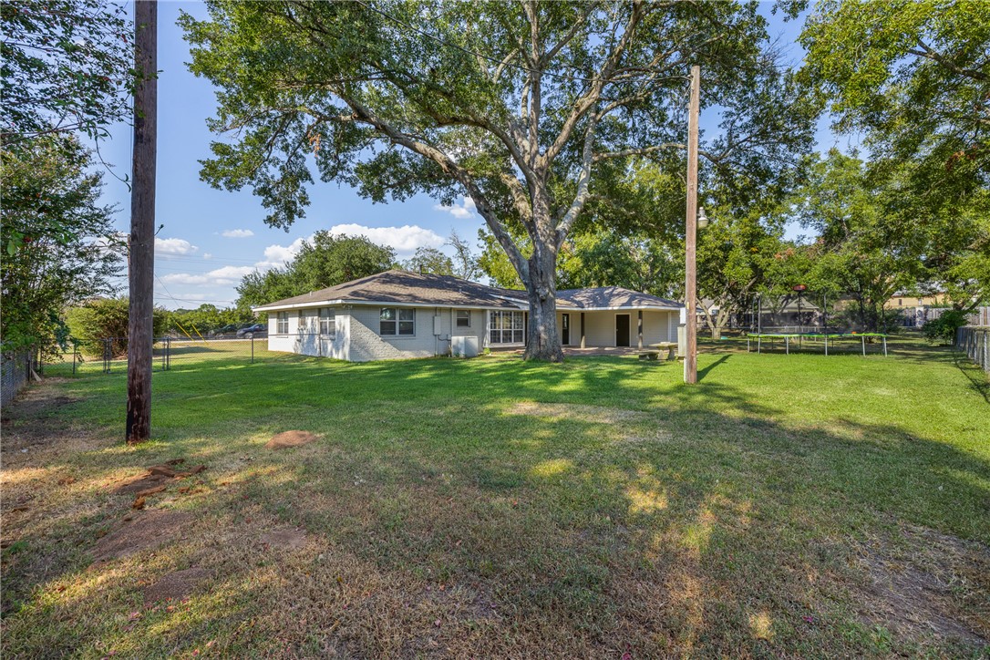 1906 Gun And Rod Road Brenham, TX 77833 - Photo 9 of 30 Fenced backyard featuring a trampoline and a patio area