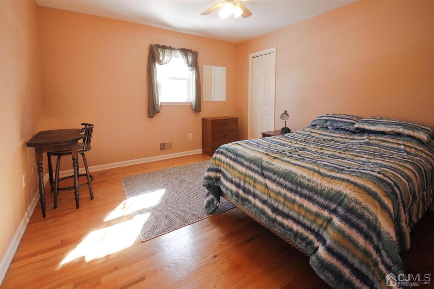 7 Markus Drive Kendall Park, NJ 08824 - Photo 29 of 47 a bedroom with a bed and a chair with the wooden floor