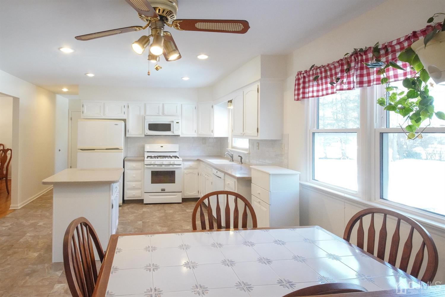 7 Markus Drive Kendall Park, NJ 08824 - Photo 35 of 47 a kitchen with a refrigerator a stove a sink dishwasher with a dining table and chairs with wooden floor