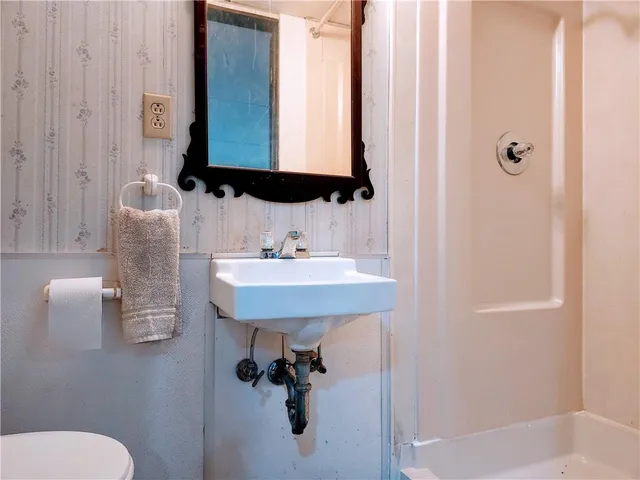 a bathroom with a sink toilet and mirror