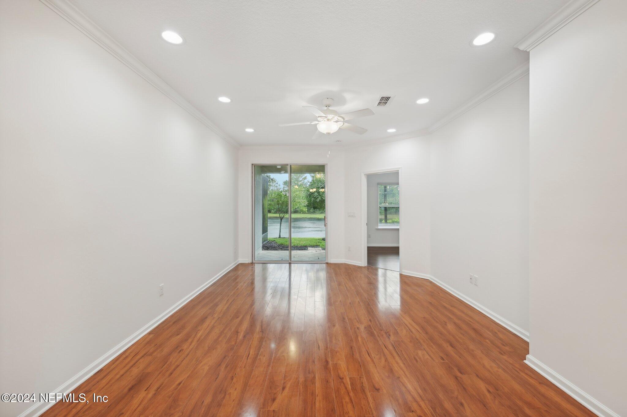 165 Amistad Drive St. Augustine, FL 32086 - Photo 14 of 41 an empty room with wooden floor and windows
