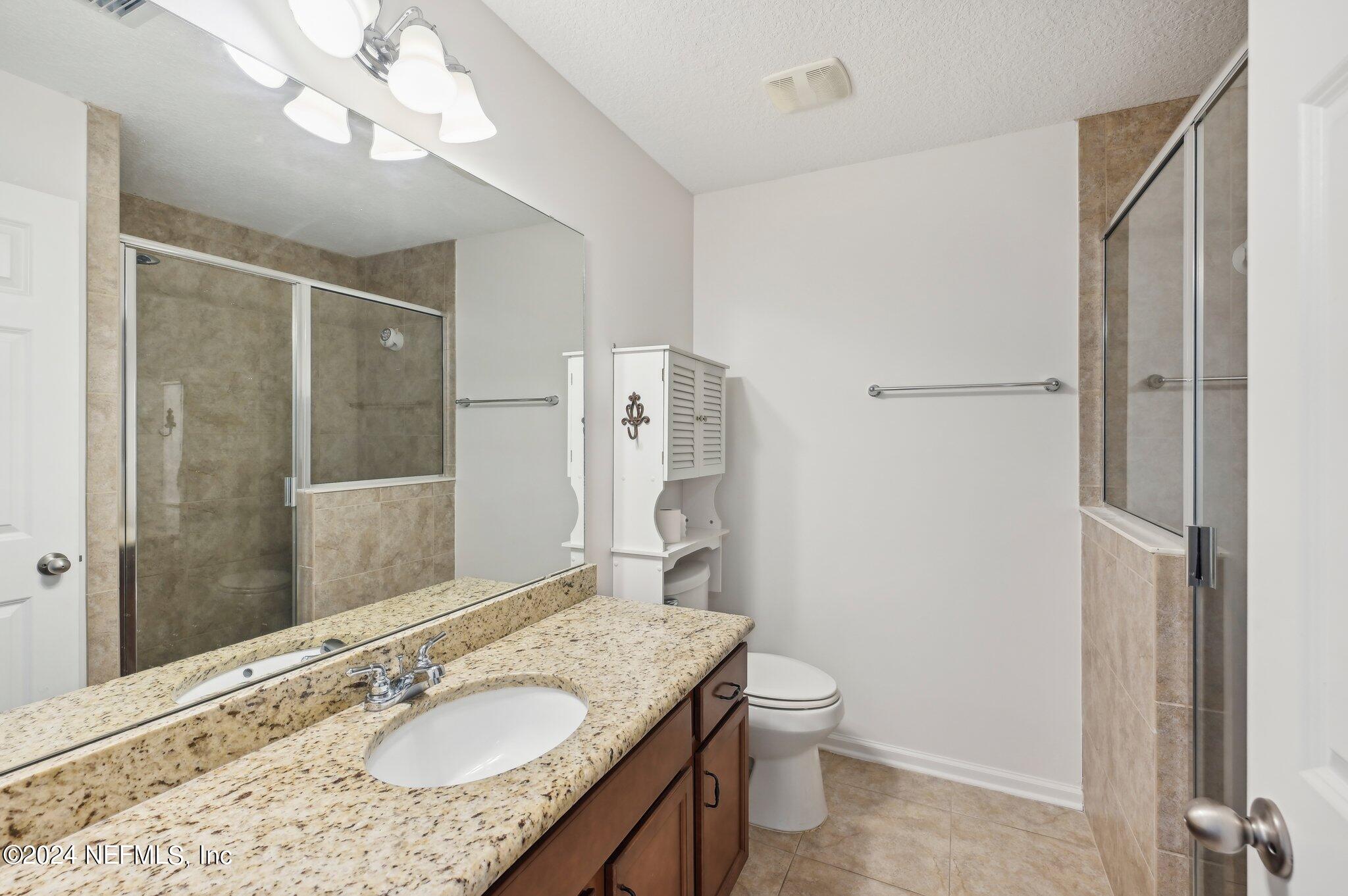 165 Amistad Drive St. Augustine, FL 32086 - Photo 28 of 41 a bathroom with a granite countertop sink toilet and shower