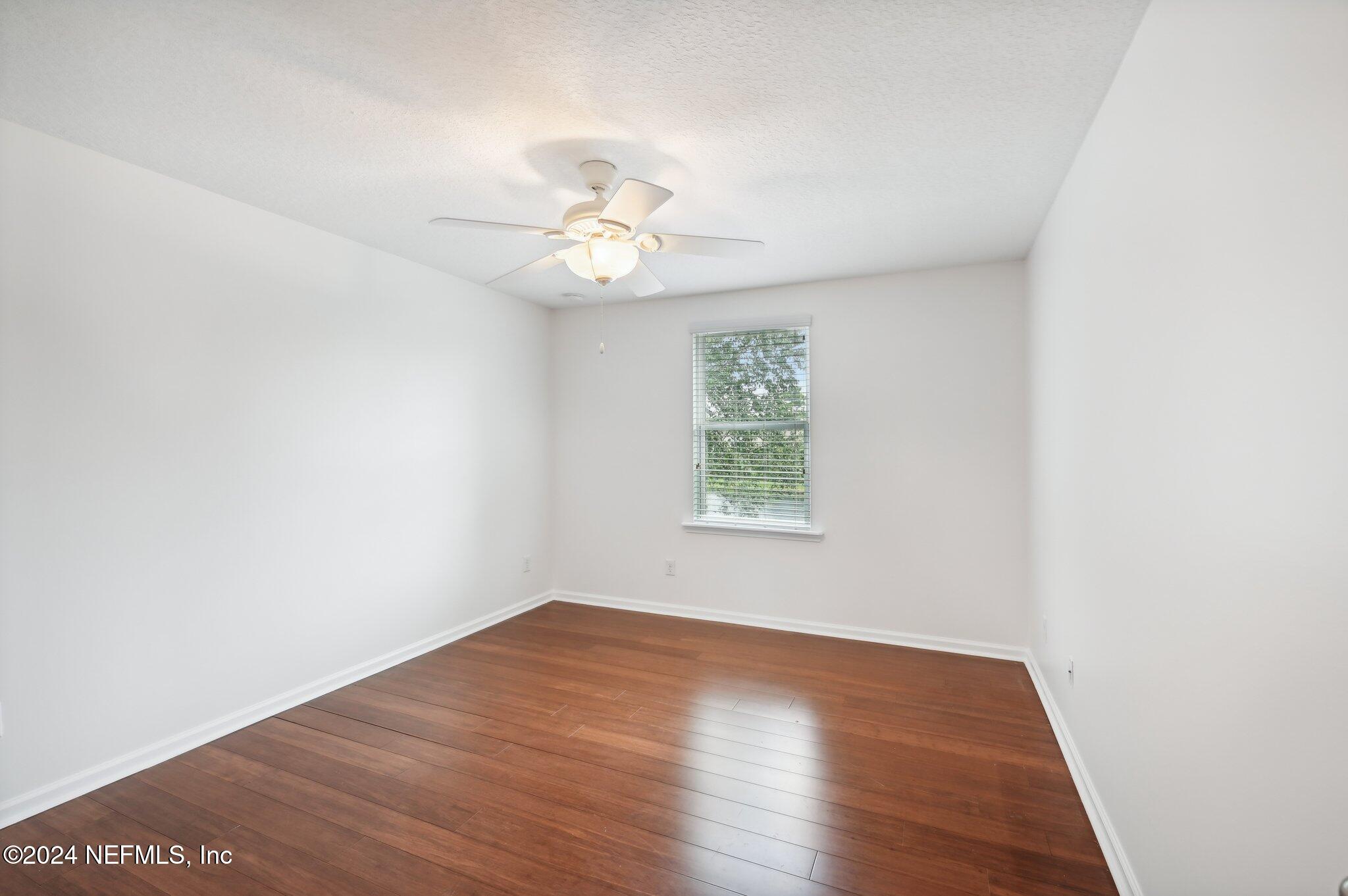 165 Amistad Drive St. Augustine, FL 32086 - Photo 32 of 41 an empty room with wooden floor and window