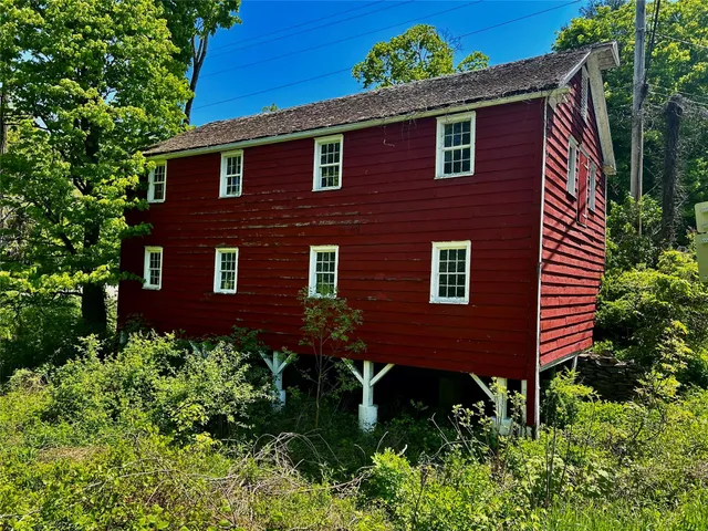 a view of a brick house with a yard and plants