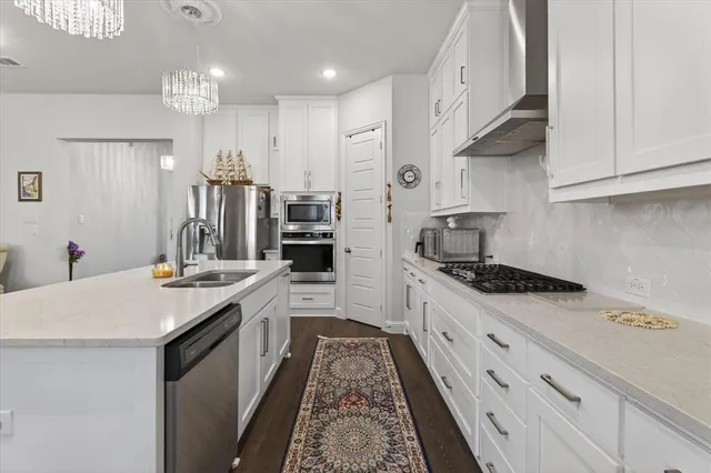 a kitchen with stainless steel appliances a sink stove and cabinets