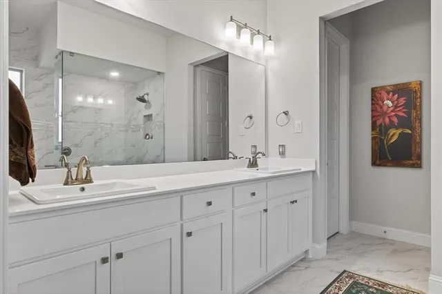 a bathroom with double vanity sinks a vanity a lamp and a mirror