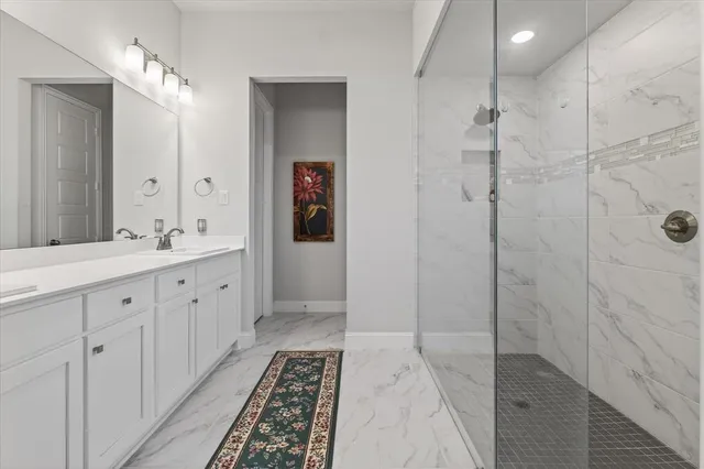 a spacious bathroom with double vanity sink and shower