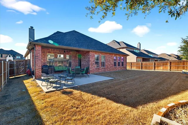 a view of a house with backyard and sitting area