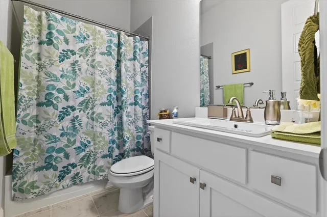 a bathroom with a granite countertop sink a toilet and a mirror
