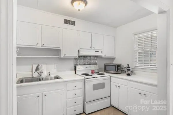 a kitchen with cabinets appliances a sink and a window