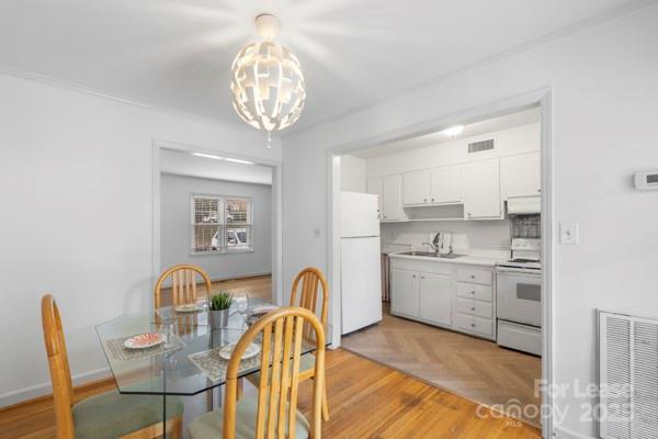 918 McAlway Road, Unit B Charlotte, NC 28211 - Photo 15 of 28 a kitchen with stainless steel appliances granite countertop a stove top oven a sink dishwasher and white cabinets with wooden floor