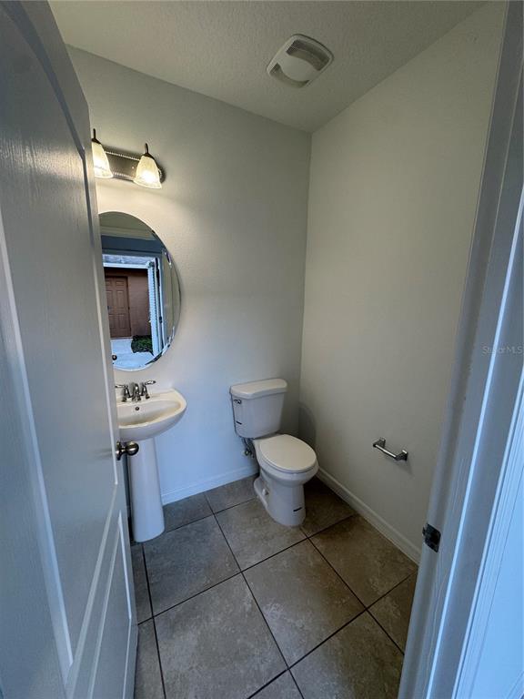 7708 Bexton Lane Windermere, FL 34786 - Photo 5 of 11 a bathroom with a toilet a sink and mirror