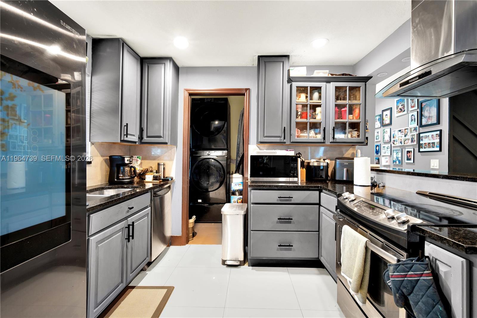 2771 Northwest 8th Street Pompano Beach, FL 33069 - Photo 6 of 27 a kitchen with stainless steel appliances granite countertop a stove and a refrigerator